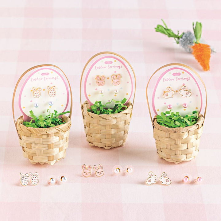 Three small woven baskets with decorative items on a pink background