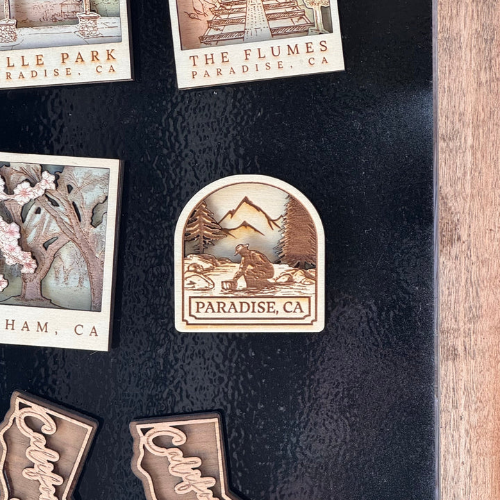 Collection of decorative magnets on a dark surface with a wooden frame.