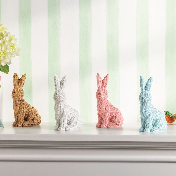 Decorative bunny figurines on a shelf with a striped background