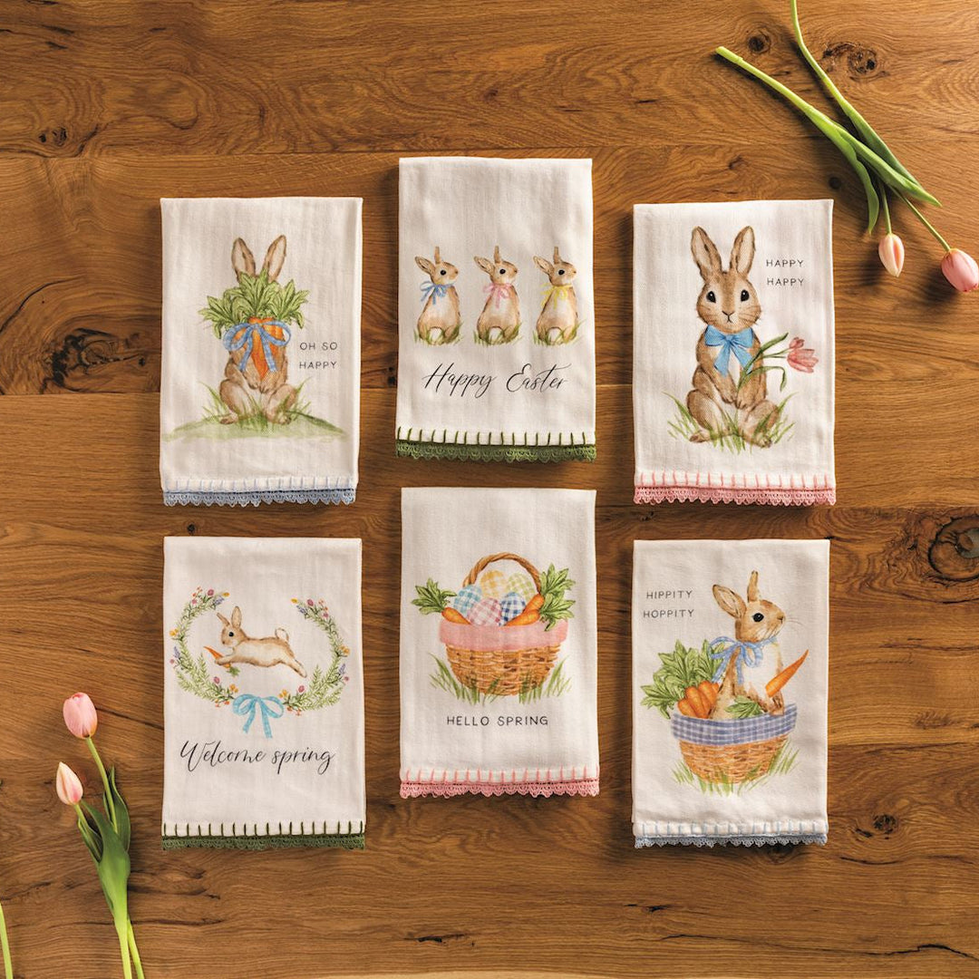 Set of Easter-themed kitchen towels on a wooden surface with tulips.