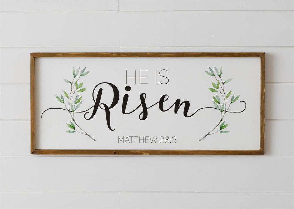 Decorative sign with 'He Is Risen' text and foliage on a white background