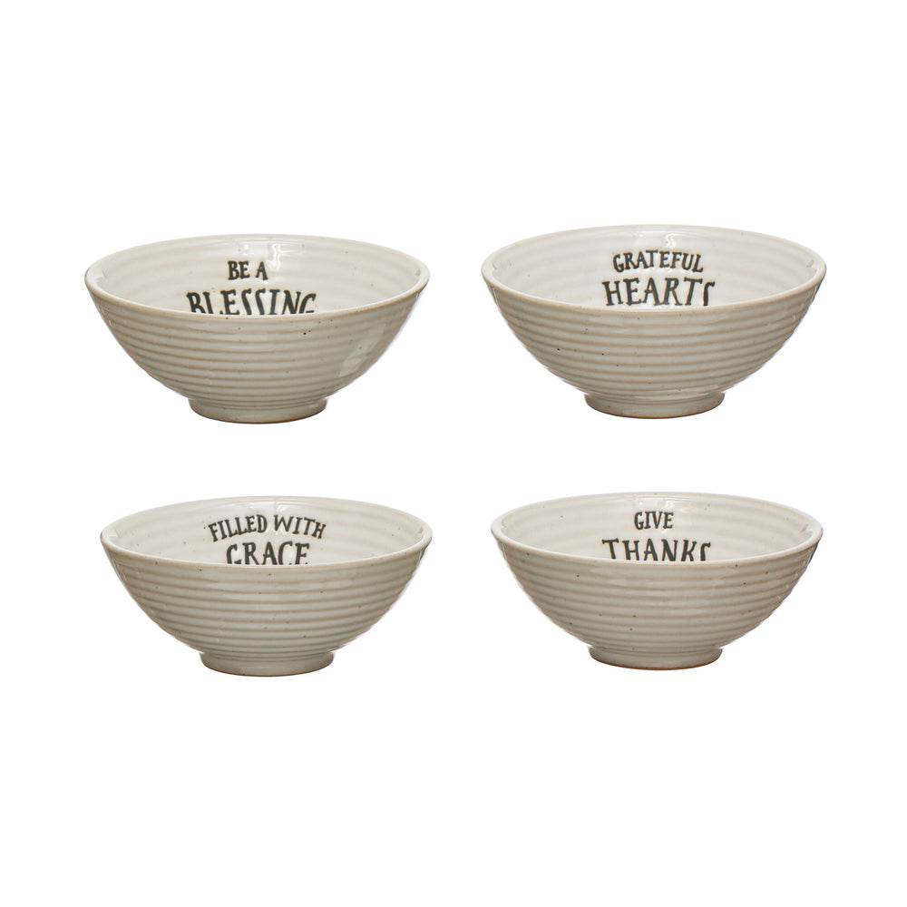 Four ceramic bowls with motivational phrases on a white background