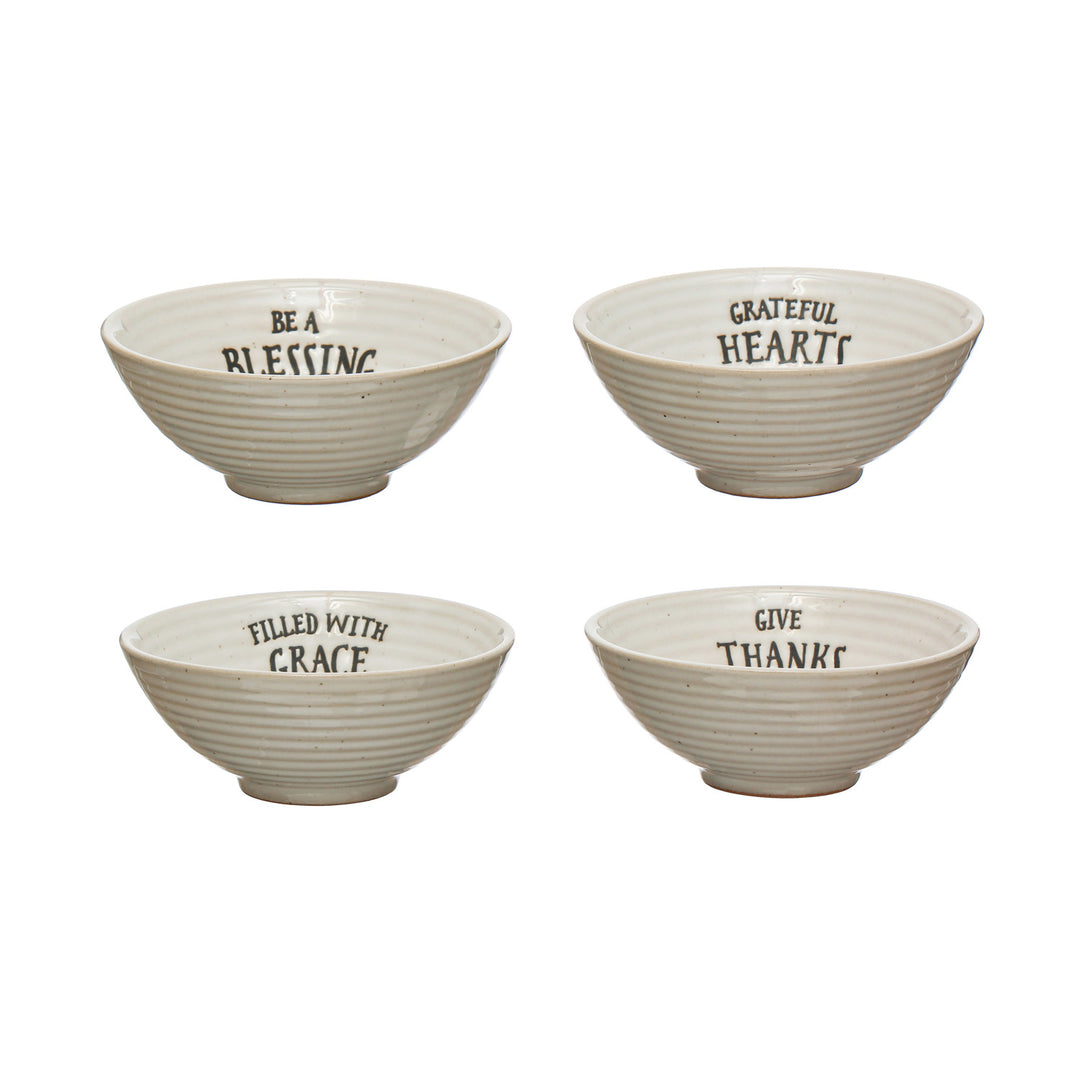 Four ceramic bowls with motivational phrases on a white background