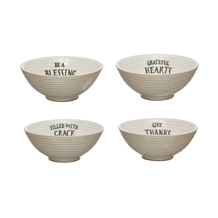 Four ceramic bowls with motivational phrases on a white background