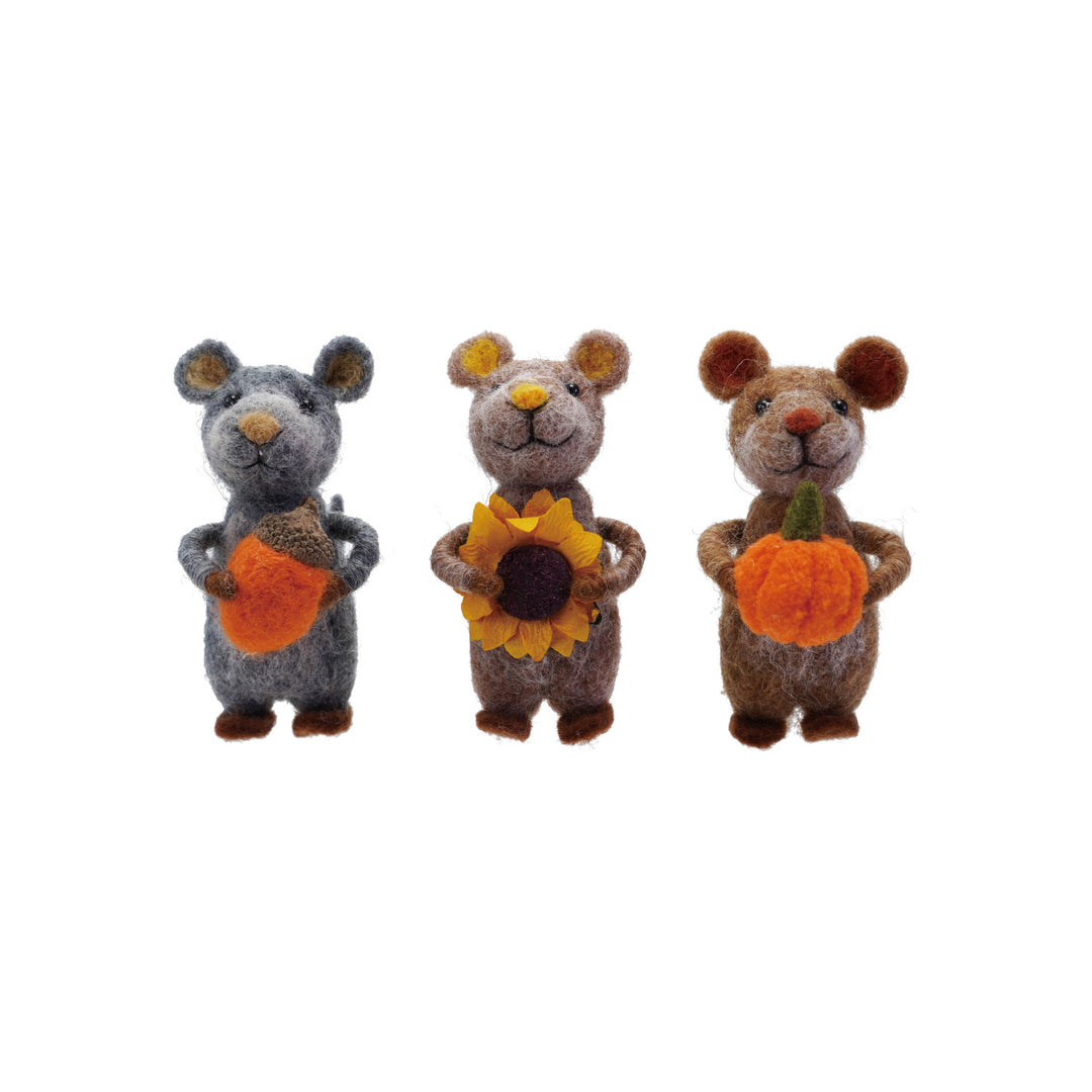 Three felted mouse toys holding pumpkins and a sunflower on a white background
