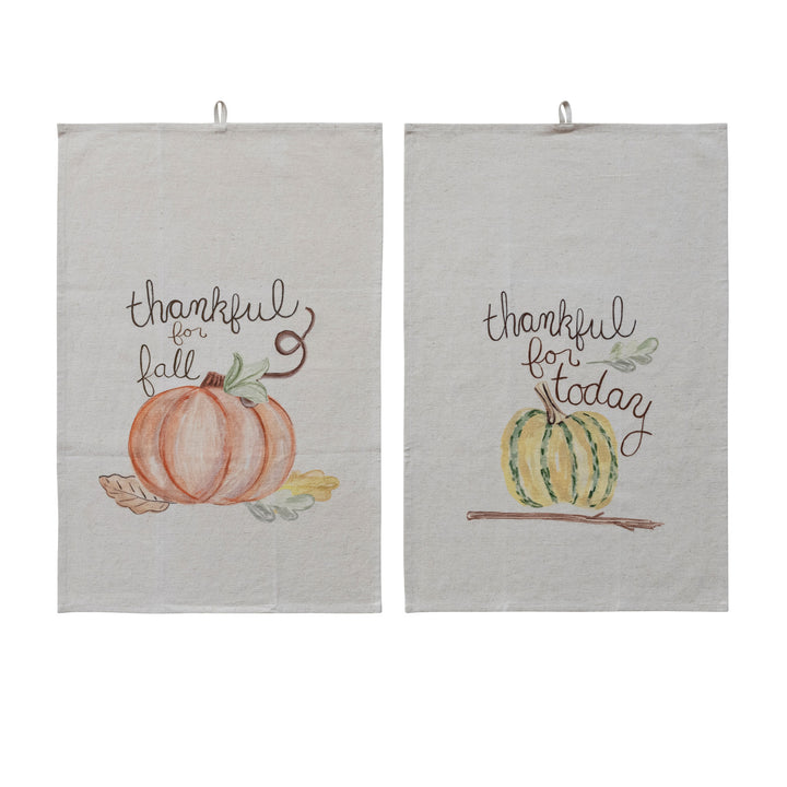 Two light beige fabric hanging kitchen towels with autumn watercolor designs. The left towel reads &
