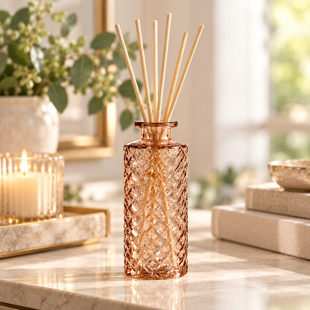 Champagne Amber textured glass vase used as a reed diffuser with natural rattan reeds in a warm neutral home setting.