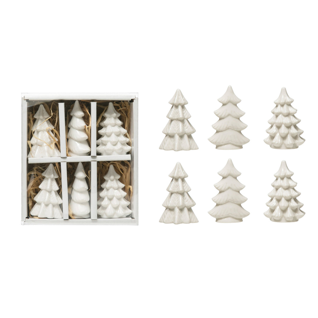 Set of white ceramic Christmas tree-shaped candles with six in a box and six displayed separately on a white background.