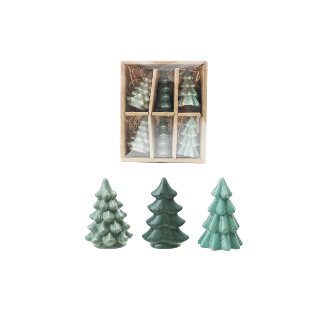 Set of green ceramic Christmas tree decorations with a wooden box on a white background
