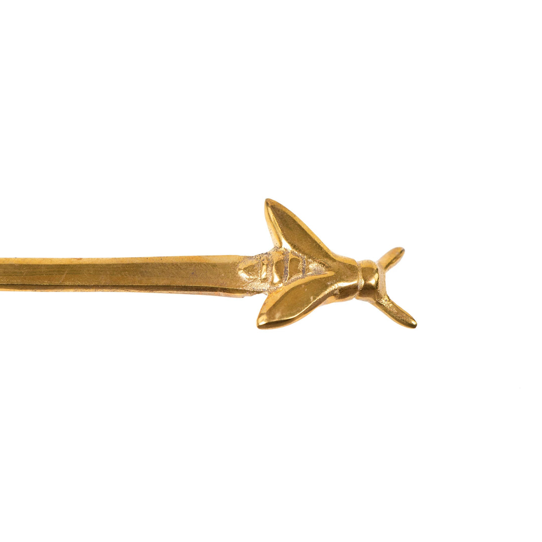 Gold-colored hairpin with fish design on a white background