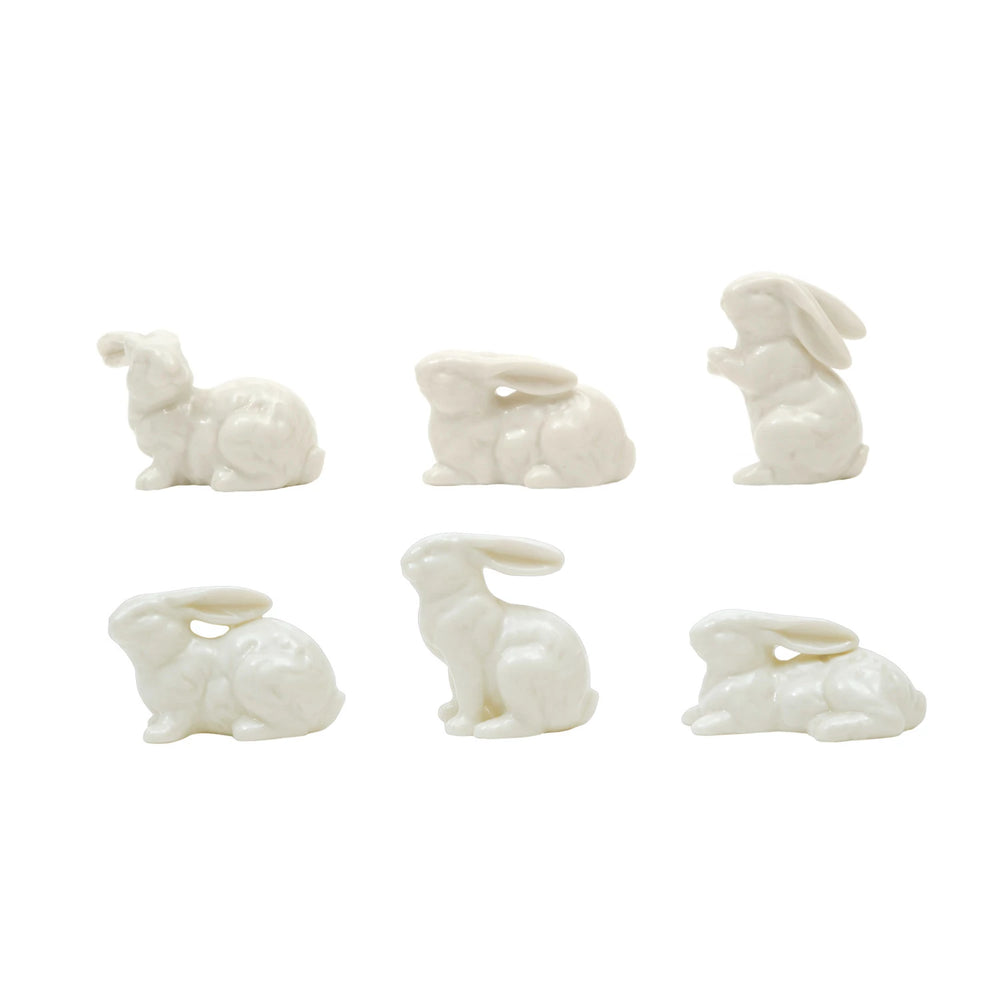 Set of six white ceramic rabbit-shaped candle holders on a white background