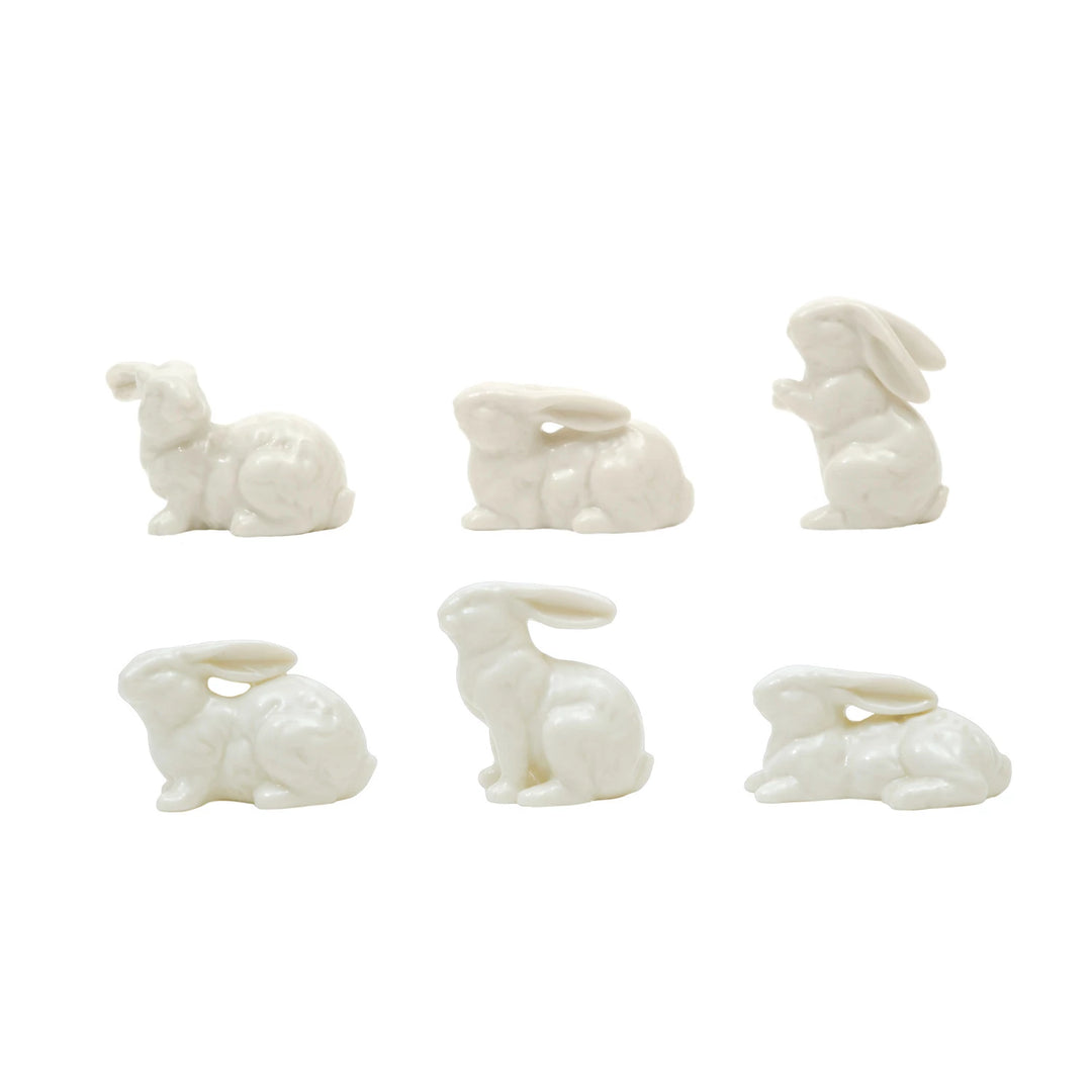 Set of six white ceramic rabbit-shaped candle holders on a white background