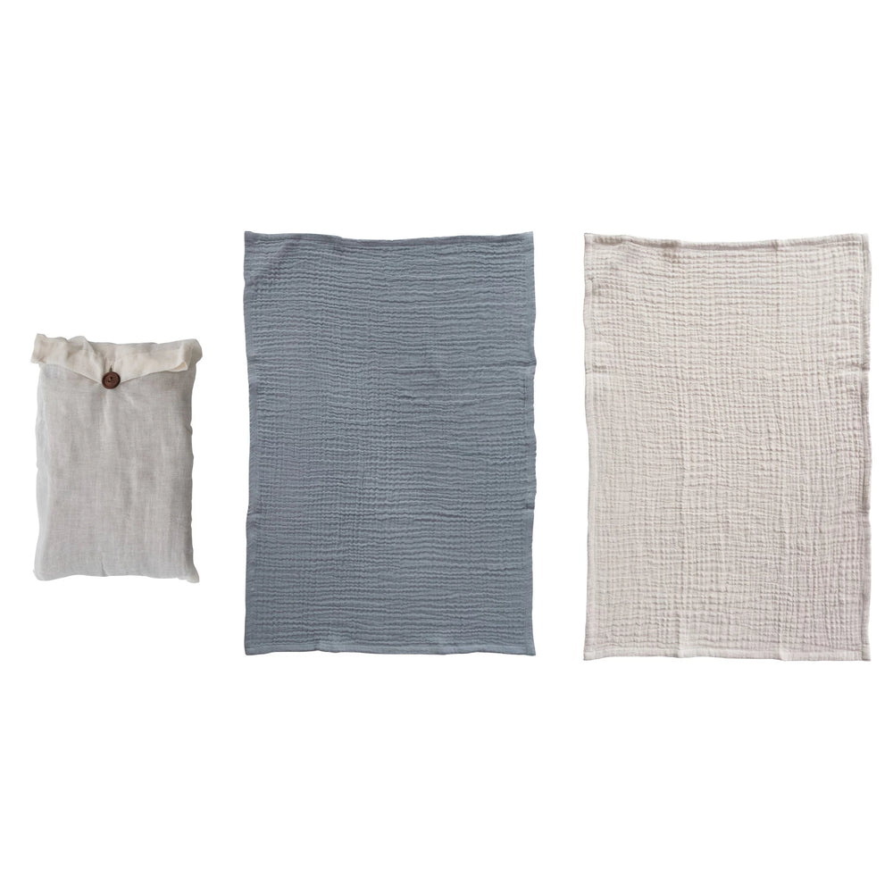 Three fabric items on a white background: a small pouch, a rectangular blue fabric piece, and a larger textured beige fabric piece.
