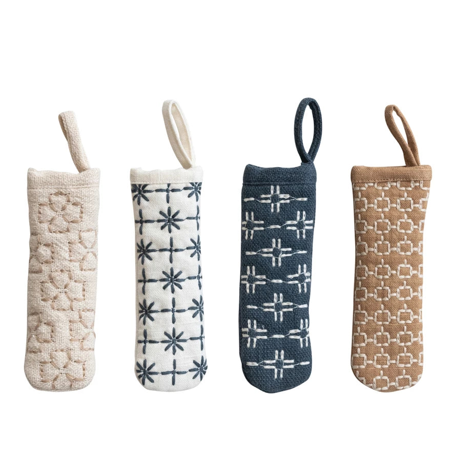 Four textured fabric bags with different patterns on a white background