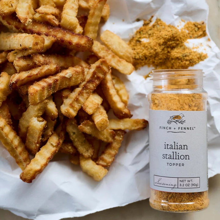 Fries with a jar of 'Italian Stallion' seasoning on white paper