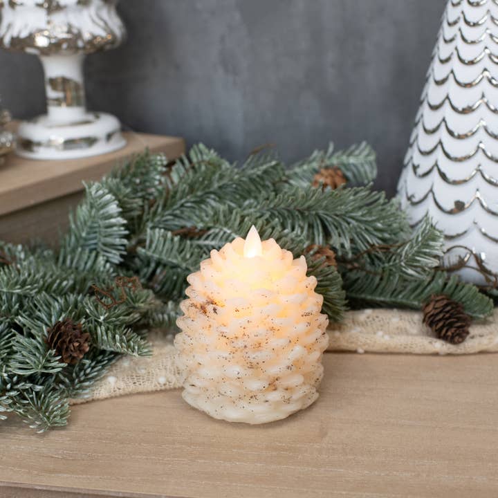 4.25-inch cream pinecone flameless candle with layered scales, speckled accents and moving flame