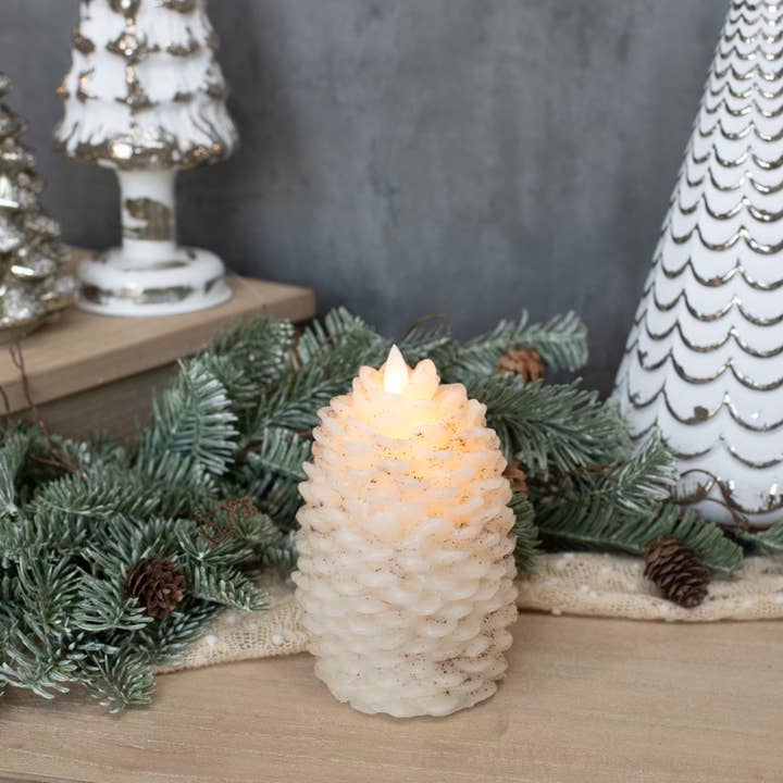 6-inch cream pinecone flameless candle with layered scales, speckled accents and moving flame