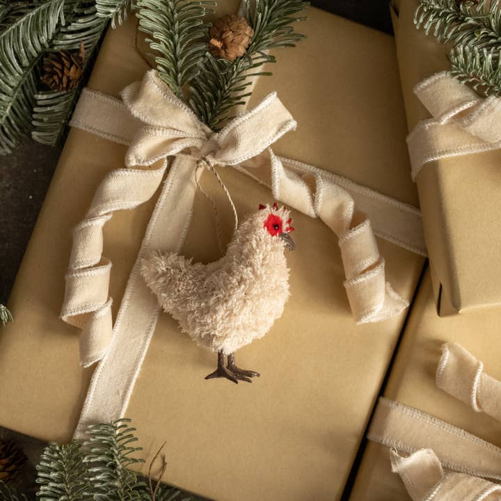 Beige hen hanging ornament with shaggy texture, red comb and dark beak and feet