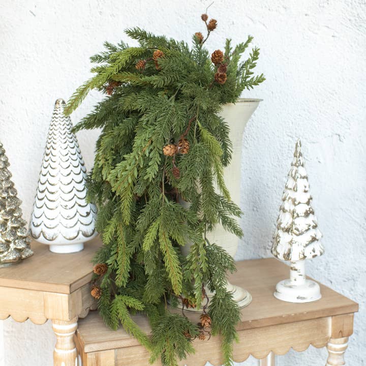 Green white spruce and tsuga hemlock hanging vine with cascading foliage and brown pinecones
