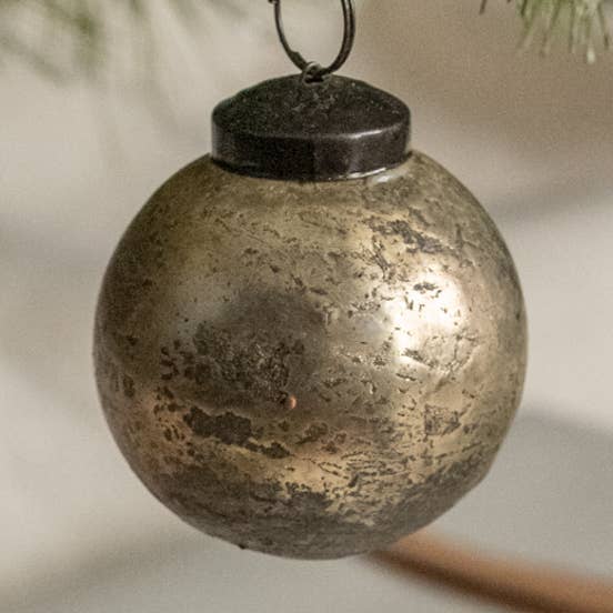 Silver-toned round Christmas ornament with a mottled crackle finish, dark cap, and circular hanging loop