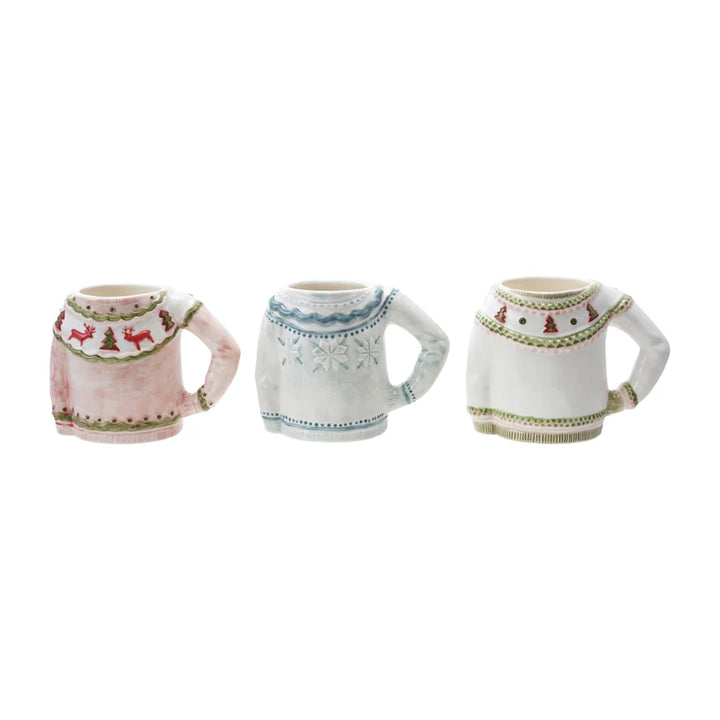Three mugs with sweater designs on a white background